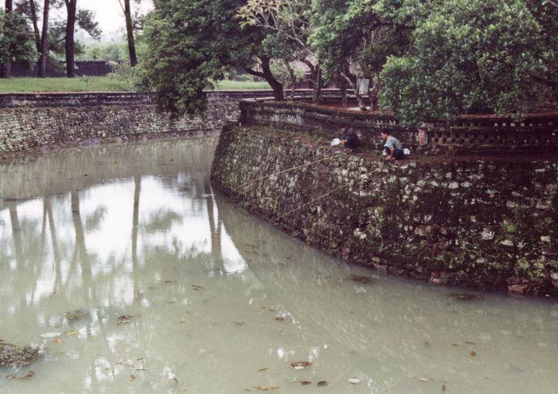 Fishing in the moat of a temple.